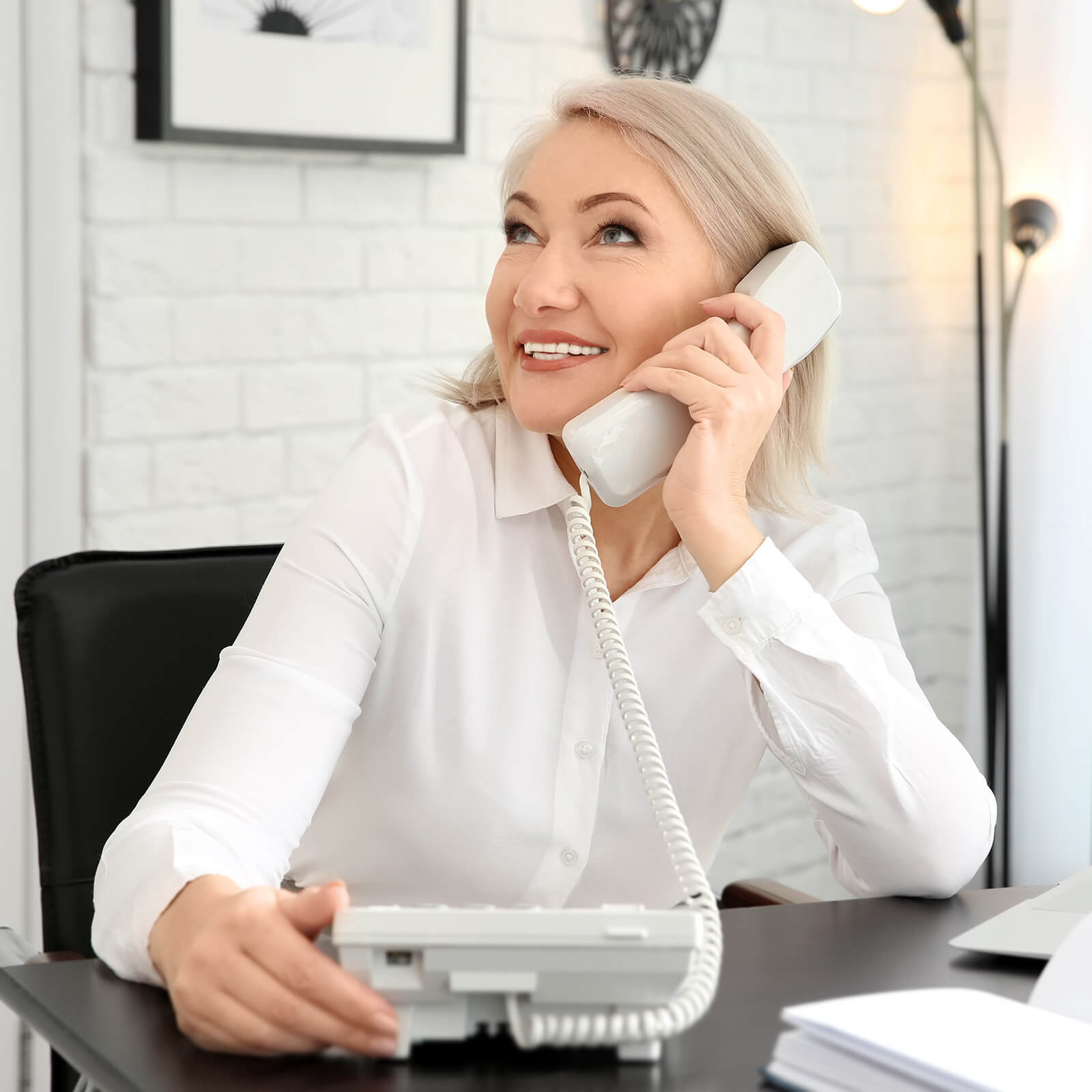 Image of a middle-aged woman on a landline phone